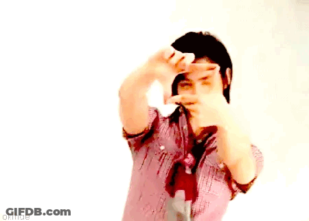 A Man In A Plaid Shirt And Tie Is Making A Frame With His Hands GIF