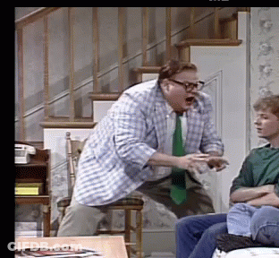 A Man In A Plaid Shirt And Tie Is Standing In Front Of A Man In A Green Shirt GIF