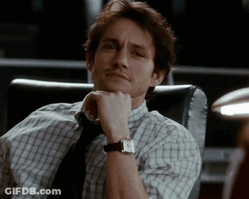 A Man In A Plaid Shirt And Tie Is Wearing A Watch GIF