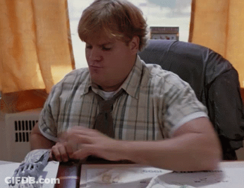 A Man In A Plaid Shirt And Tie Sits At His Desk GIF