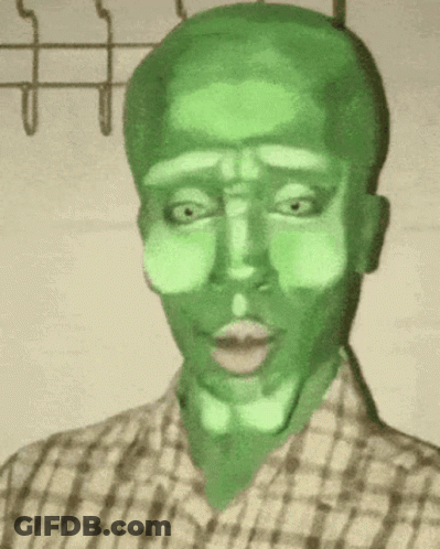 A Man In A Plaid Shirt Has A Green Face Painted On His Face . GIF