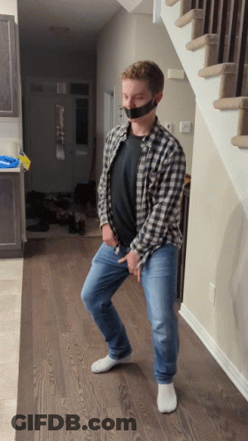 A Man In A Plaid Shirt Has Duct Tape On His Mouth GIF