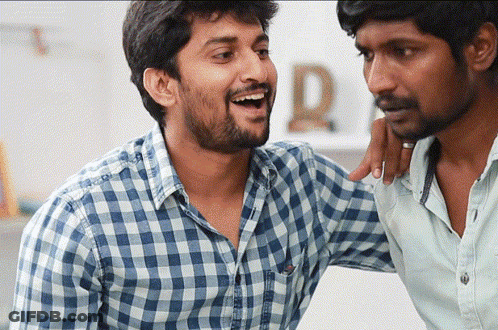 A Man In A Plaid Shirt Has His Arm Around Another Man GIF