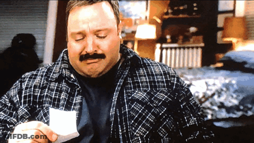 A Man In A Plaid Shirt Holds A Piece Of Paper In His Hand GIF
