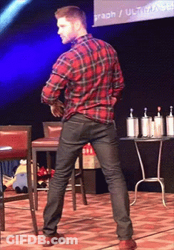 A Man In A Plaid Shirt Is Dancing In Front Of A Screen That Says Graph / Ultracab GIF