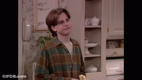 A Man In A Plaid Shirt Is Holding A Banana GIF