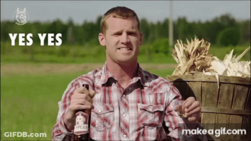 A Man In A Plaid Shirt Is Holding A Bottle Of Pears GIF