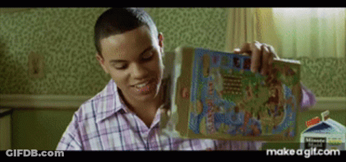 A Man In A Plaid Shirt Is Holding A Box Of Cereal In His Hand . GIF