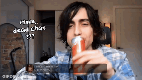 A Man In A Plaid Shirt Is Holding A Can Of Soda And Says Hmm Dead Chat GIF