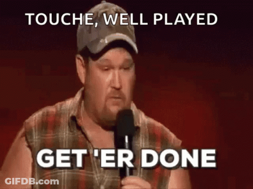 A Man In A Plaid Shirt Is Holding A Microphone And Saying `` Touch , Well Played Get 'Er Done '' . GIF