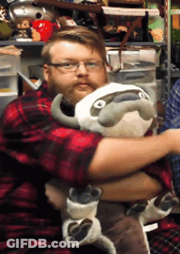 A Man In A Plaid Shirt Is Hugging A Stuffed Animal GIF