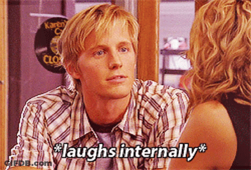 A Man In A Plaid Shirt Is Laughing Internally GIF