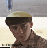 A Man In A Plaid Shirt Is Looking At The Camera With A Pen On His Head GIF