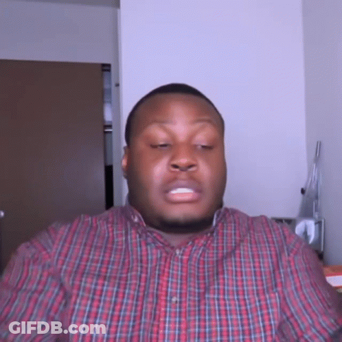 A Man In A Plaid Shirt Is Making A Face GIF