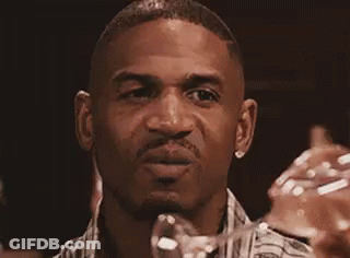 A Man In A Plaid Shirt Is Making A Funny Face . GIF
