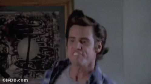 A Man In A Plaid Shirt Is Making A Funny Face In Front Of A Picture . GIF