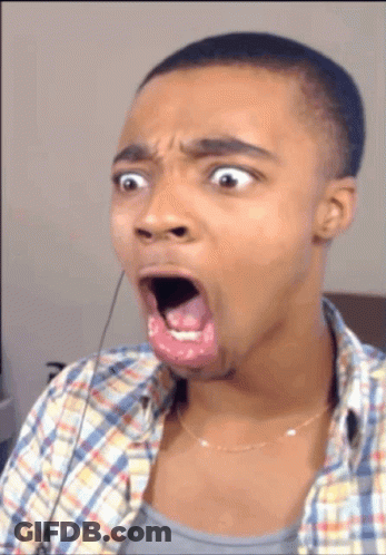 A Man In A Plaid Shirt Is Making A Funny Face With His Mouth Open GIF