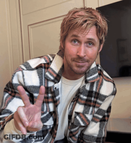 A Man In A Plaid Shirt Is Making A Peace Sign GIF
