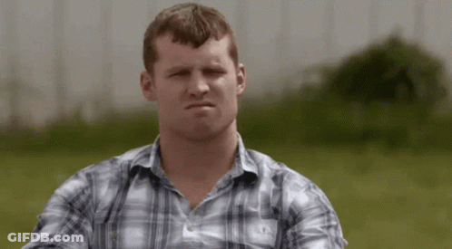 A Man In A Plaid Shirt Is Making A Serious Face GIF