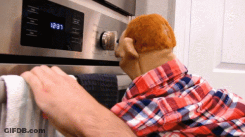 A Man In A Plaid Shirt Is Putting A Towel On A Towel Rack In Front Of An Oven That Says 12:31 GIF