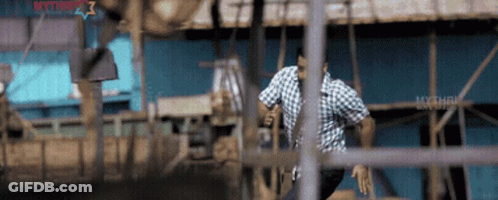 A Man In A Plaid Shirt Is Running Through A Fence With The Word Mythri On The Bottom Right GIF