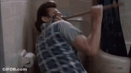 A Man In A Plaid Shirt Is Sitting In A Bathroom Holding A Toilet Paper Roll . GIF