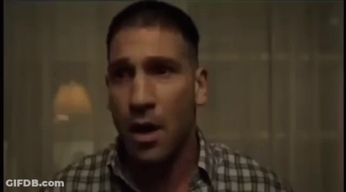 A Man In A Plaid Shirt Is Sitting In A Chair And Crying GIF