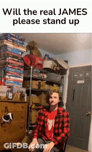 A Man In A Plaid Shirt Is Sitting In Front Of A Stack Of Board Games And A Sign That Says Will The Real James GIF