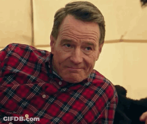 A Man In A Plaid Shirt Is Sitting In Front Of A Tent And Smiling . GIF