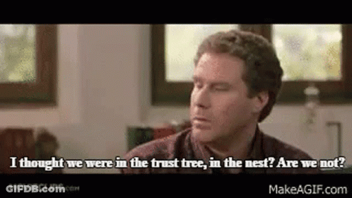 A Man In A Plaid Shirt Is Sitting In Front Of A Window And Talking To Someone . GIF