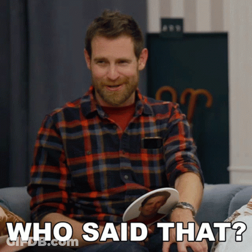 A Man In A Plaid Shirt Is Sitting On A Couch And Holding A Picture Of A Man And Says Who Said That GIF