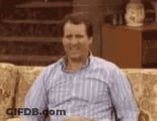 Man Sitting On Couch In Plaid Shirt GIF