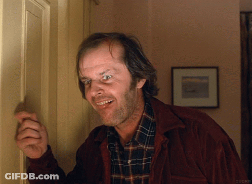 A Man In A Plaid Shirt Is Smiling While Standing In Front Of A Door That Says Iucrm GIF
