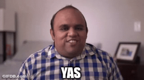 A Man In A Plaid Shirt Is Smiling With The Word Yas On His Face . GIF