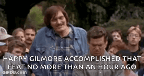 A Man In A Plaid Shirt Is Standing In Front Of A Crowd . GIF