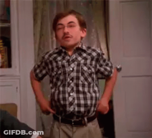 A Man In A Plaid Shirt Is Standing In Front Of A Door With The Word Fashion Written On It . GIF