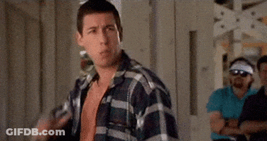 A Man In A Plaid Shirt Is Standing In Front Of A Group Of Men In A Room . GIF