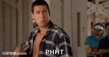 A Man In A Plaid Shirt Is Standing In Front Of A Group Of Men In A Room . GIF