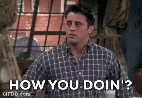 A Man In A Plaid Shirt Is Standing In Front Of A Window And Asking How You Doin ' ? GIF
