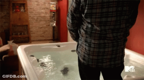 A Man In A Plaid Shirt Is Standing Next To A Hot Tub That Says Mtv GIF