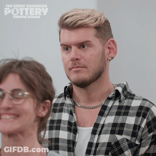 A Man In A Plaid Shirt Is Standing Next To A Woman With Glasses And The Words The Great Canadian Pottery Throw Down GIF