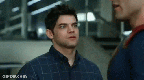 A Man In A Plaid Shirt Is Standing Next To Another Man In A Superman Costume . GIF