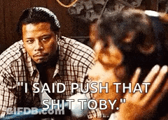 A Man In A Plaid Shirt Is Talking To A Woman Who Is Holding A Baby . GIF