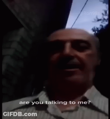 A Man In A Plaid Shirt Is Talking To Someone And Says Are You Talking To Me ? GIF