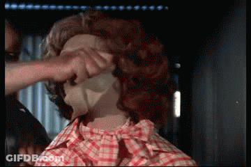 A Man In A Plaid Shirt Is Touching A Woman 'S Face GIF