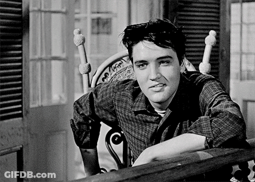 A Man In A Plaid Shirt Leans On A Railing GIF