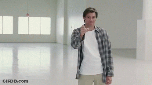 A Man In A Plaid Shirt Points At The Camera GIF