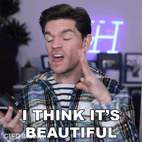 A Man In A Plaid Shirt Says " I Think It 'S Beautiful " While Holding A Camera GIF