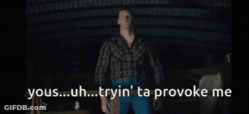 A Man In A Plaid Shirt Stands In A Dark Room With The Words Yous Uh Tryin ' Ta Provoke Me GIF