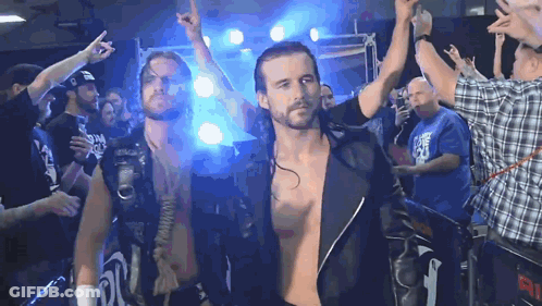 A Man In A Plaid Shirt Stands In Front Of A Crowd With The Number 91 On The Back GIF